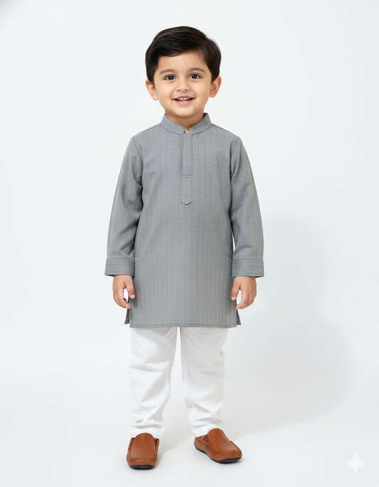 Child wearing a gray kurta with white pants on a white background